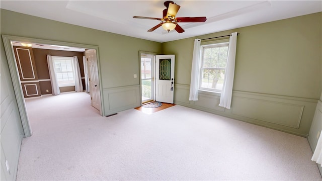 112 N 3rd St, Hoopeston, IL 60942 - spare room featuring light carpet, healthy amount of natural light, ceiling fan, a decorative wall, and wainscoting