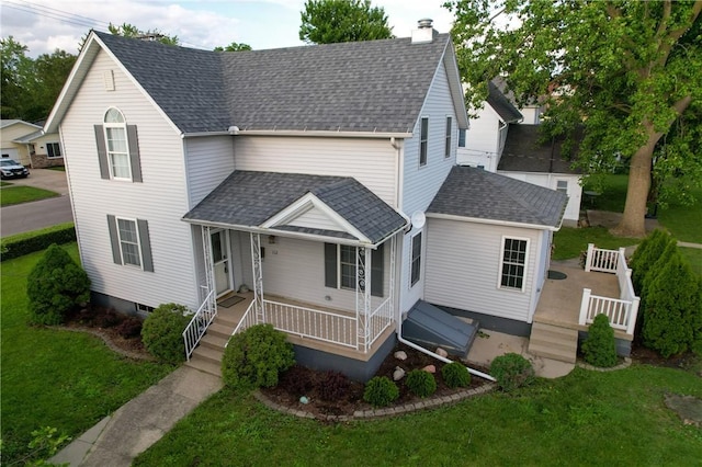 112 N 3rd St, Hoopeston, IL 60942 - traditional home with a porch, a shingled roof, a front lawn, and a chimney