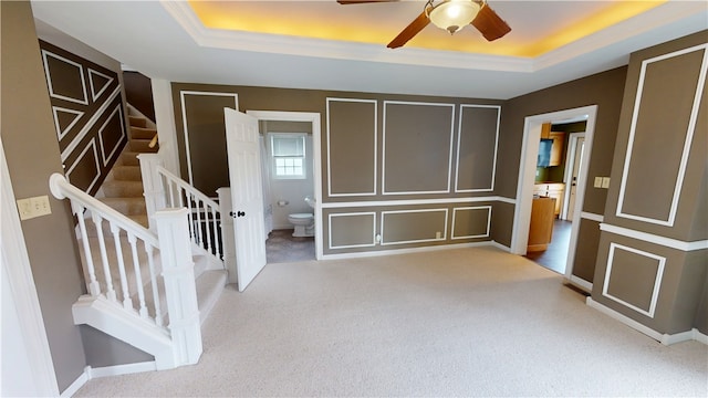 112 N 3rd St, Hoopeston, IL 60942 - carpeted entrance foyer with a tray ceiling, ceiling fan, stairs, a decorative wall, and ornamental molding