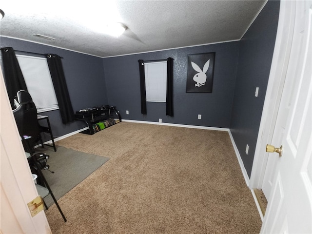 unfurnished office featuring carpet flooring, visible vents, baseboards, and a textured ceiling