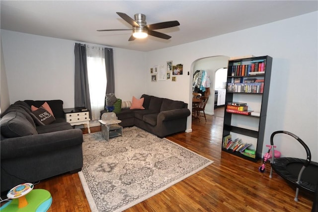 living room with dark hardwood / wood-style flooring and ceiling fan