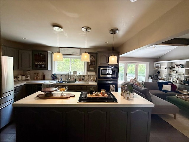 141 Hightide Dr, Decatur, IL 62521 - kitchen featuring a sink, stainless steel appliances, light countertops, a kitchen island, and glass insert cabinets