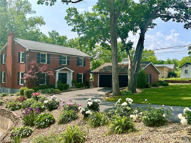 141 Hightide Dr, Decatur, IL 62521 - colonial home featuring a garage, concrete driveway, a chimney, a front lawn, and brick siding