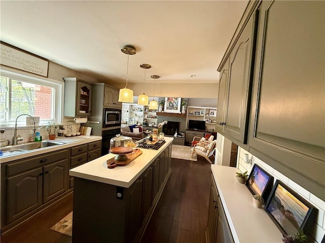 141 Hightide Dr, Decatur, IL 62521 - kitchen featuring a sink, stainless steel microwave, a fireplace, light countertops, and a kitchen island