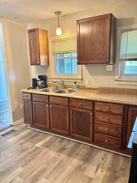 1414 14th St, Charleston, IL 61920 - kitchen with light wood finished floors, light countertops, a sink, and decorative light fixtures
