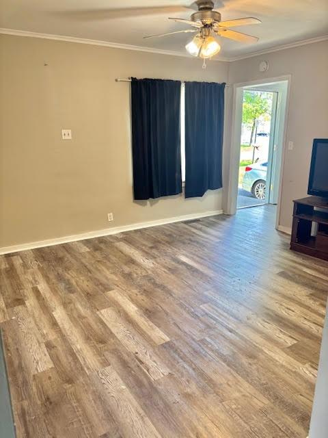 1414 14th St, Charleston, IL 61920 - unfurnished living room featuring ceiling fan, ornamental molding, wood finished floors, and baseboards
