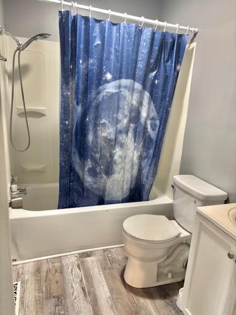 1414 14th St, Charleston, IL 61920 - full bath featuring shower / bathtub combination with curtain, wood finished floors, toilet, and vanity