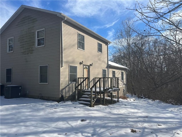 snow covered house featuring cooling unit