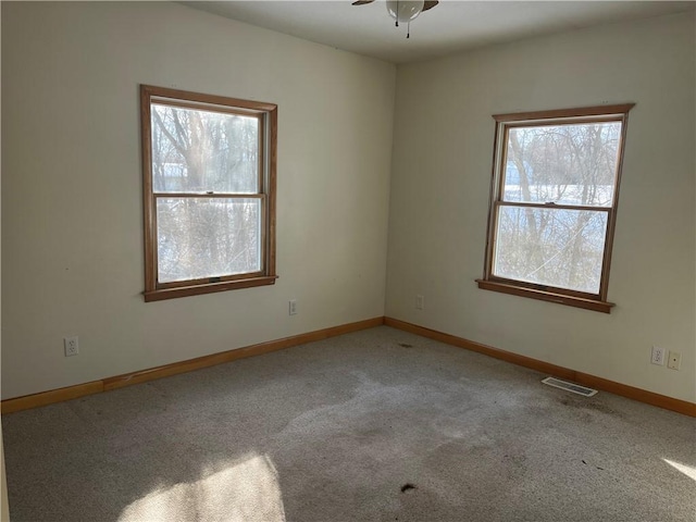 empty room with ceiling fan and carpet