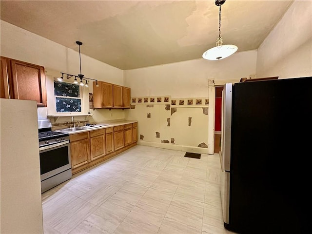 kitchen featuring appliances with stainless steel finishes, decorative light fixtures, and sink