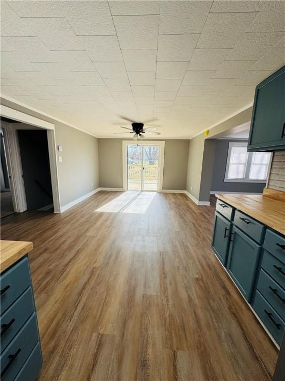 unfurnished living room featuring ceiling fan, plenty of natural light, and dark hardwood / wood-style flooring