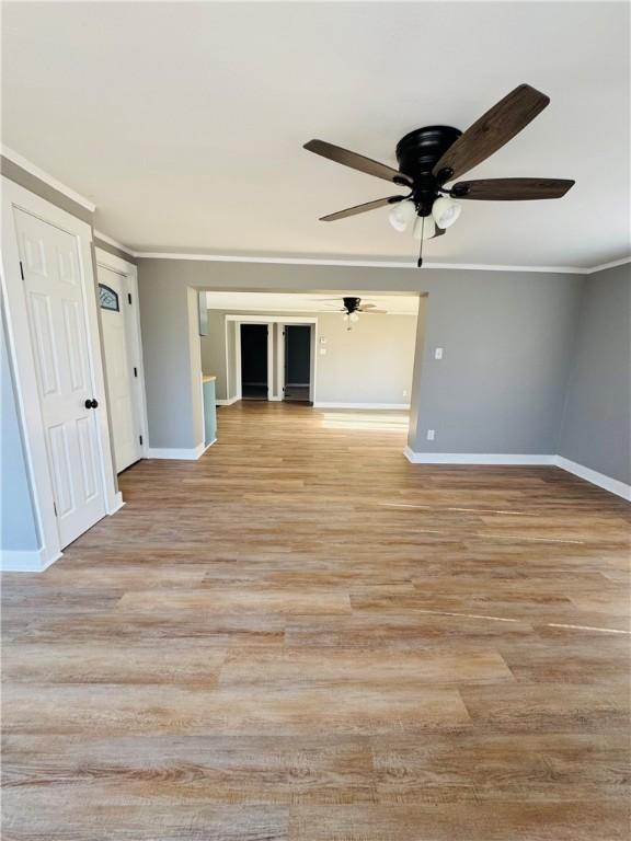 empty room with ornamental molding and light hardwood / wood-style floors