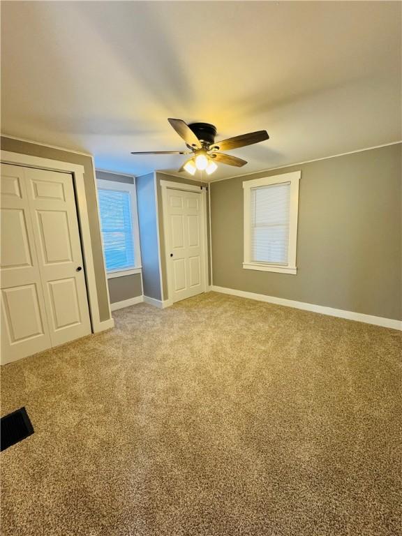 unfurnished bedroom featuring carpet and ceiling fan