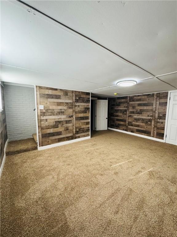 basement featuring wooden walls and carpet