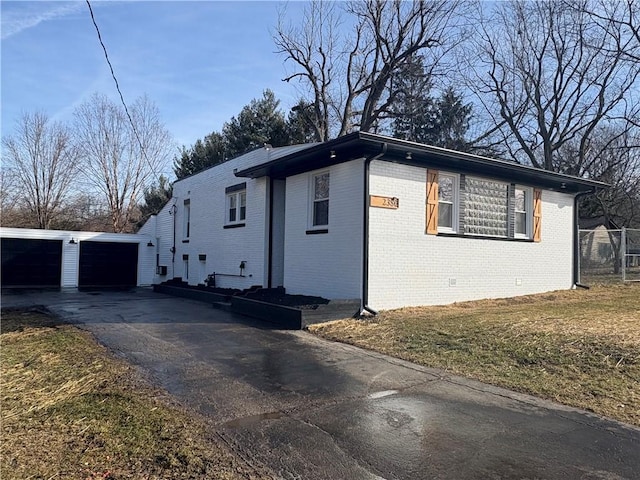 view of property exterior with a garage, an outdoor structure, and a lawn