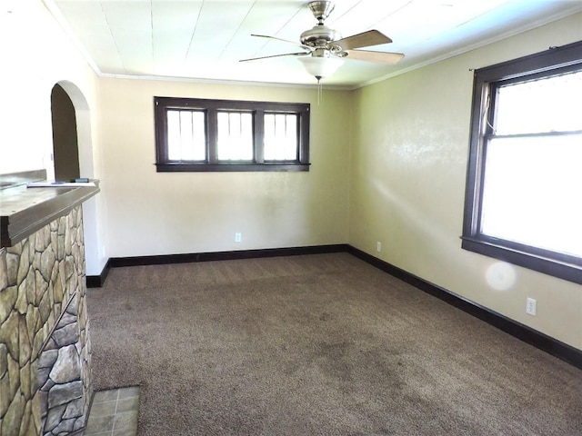 1511 Oak St, Danville, IL 61832 - spare room with crown molding, dark carpet, ceiling fan, and arched walkways
