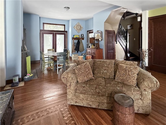 living room featuring stairway, wood-type flooring, and baseboards