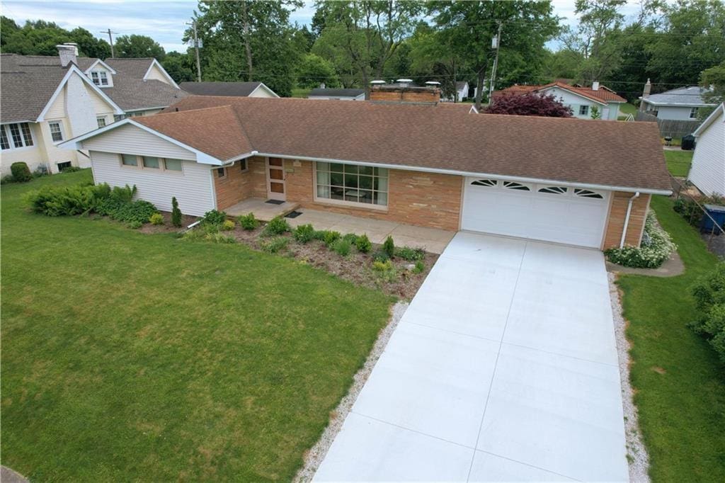 ranch-style home featuring a garage and a front yard