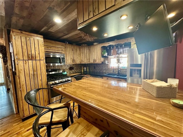 808 Moultrie Ave, Mattoon, IL 61938 - kitchen featuring appliances with stainless steel finishes, decorative backsplash, brown cabinetry, recessed lighting, and light wood-type flooring