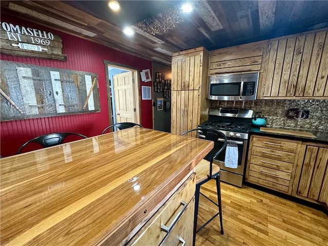 808 Moultrie Ave, Mattoon, IL 61938 - kitchen with stainless steel appliances, light wood-type flooring, brown cabinets, recessed lighting, and tasteful backsplash
