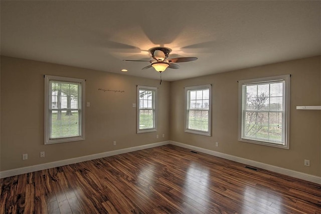 unfurnished room featuring hardwood / wood-style floors, a wealth of natural light, and visible vents