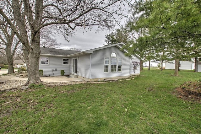 rear view of house featuring a patio and a lawn