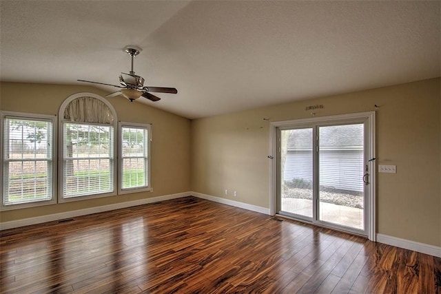 empty room with wood finished floors, lofted ceiling, baseboards, visible vents, and ceiling fan