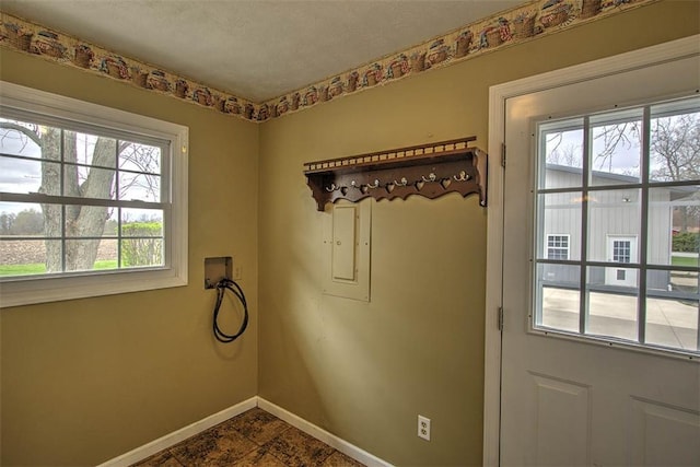 doorway to outside featuring plenty of natural light and baseboards