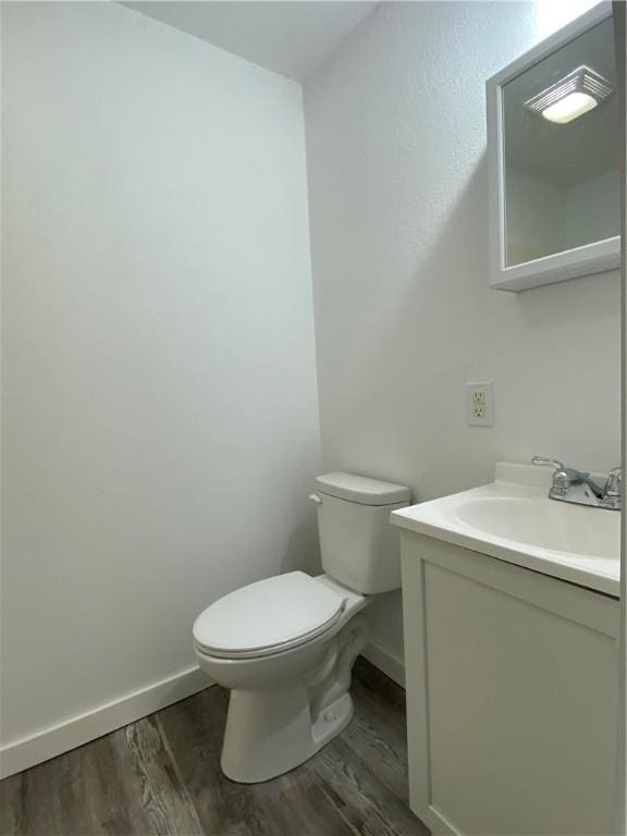 bathroom featuring hardwood / wood-style flooring, toilet, and vanity