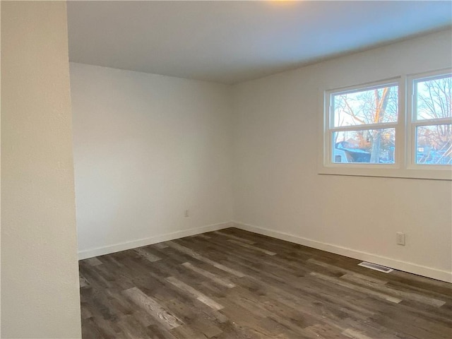 spare room featuring dark wood-type flooring