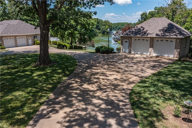 2928 Lakewood Dr, Vandalia, IL 62471 - view of front of home featuring a water view, a front yard, an outdoor structure, a detached garage, and brick siding