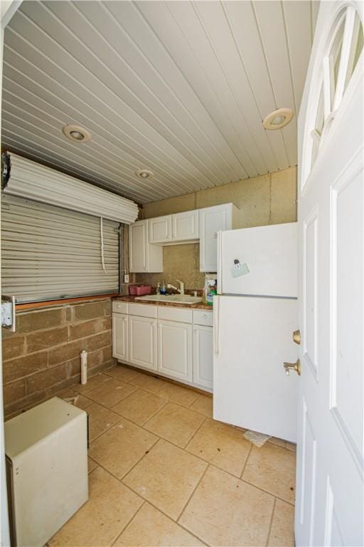 2928 Lakewood Dr, Vandalia, IL 62471 - kitchen with freestanding refrigerator, light tile patterned flooring, and white cabinets