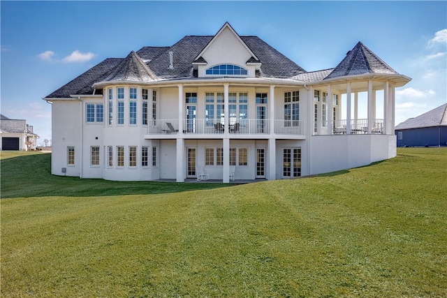 back of property featuring a yard and stucco siding