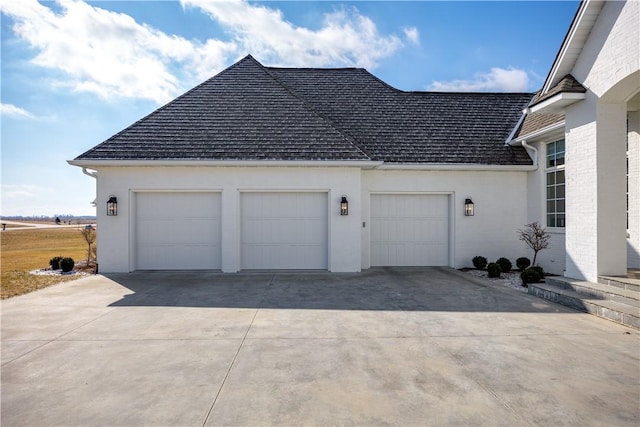 view of side of property with a shingled roof, brick siding, driveway, and an attached garage