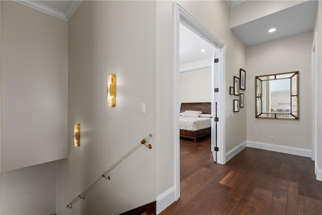 corridor with baseboards, ornamental molding, dark wood-type flooring, and an upstairs landing