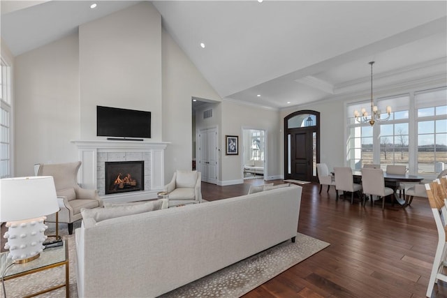 living area with a wealth of natural light, ornamental molding, dark wood-type flooring, and a tile fireplace