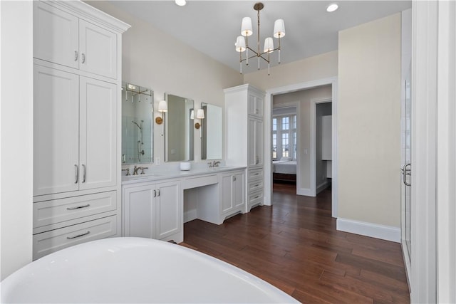 bathroom with a sink, a notable chandelier, wood finished floors, and ensuite bathroom