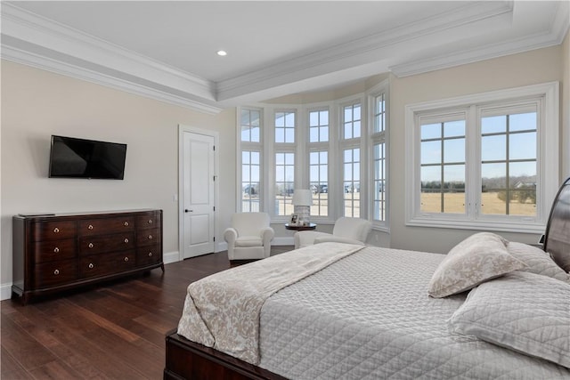 bedroom with a tray ceiling, dark wood finished floors, and crown molding