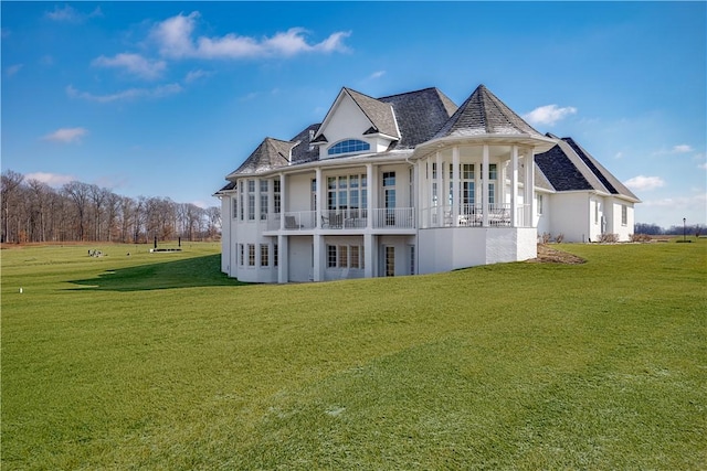 rear view of house with a lawn and stucco siding