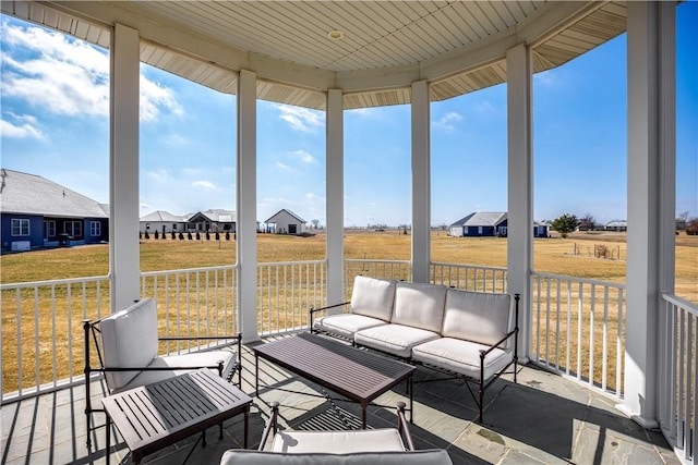 sunroom / solarium featuring a residential view and a wealth of natural light