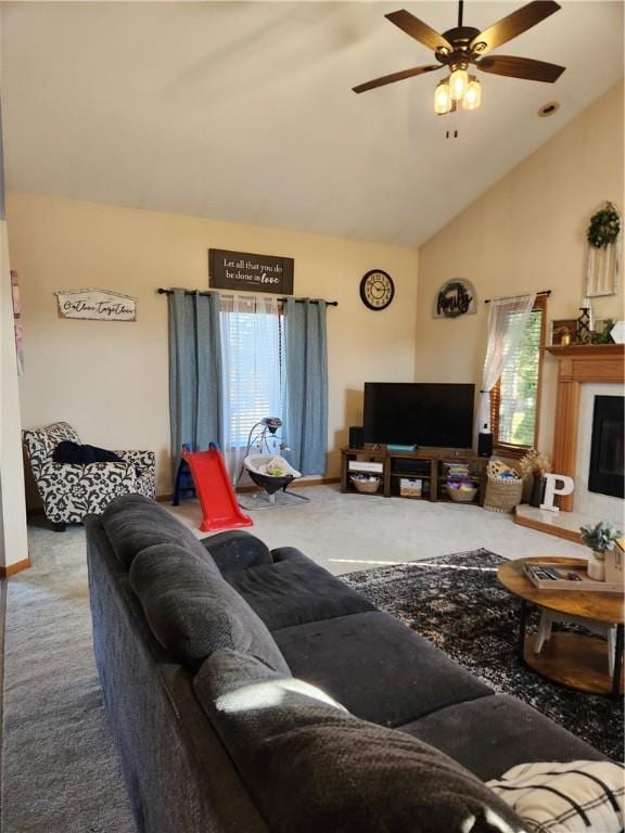 living room with a glass covered fireplace, high vaulted ceiling, ceiling fan, and carpet floors