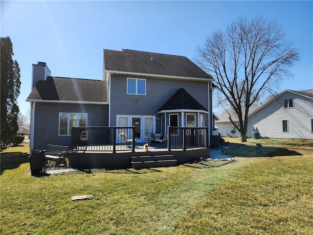 rear view of property with a wooden deck, a yard, roof with shingles, and a chimney