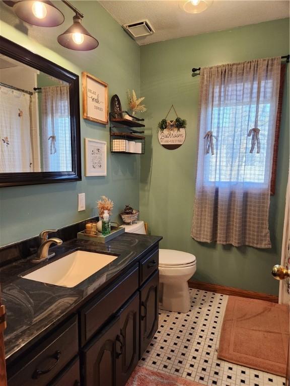 full bathroom with visible vents, toilet, tile patterned flooring, baseboards, and vanity