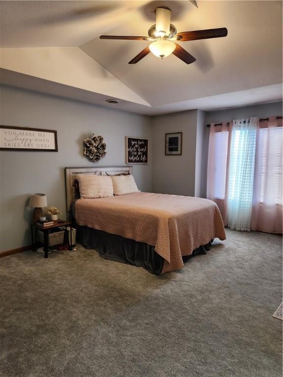 carpeted bedroom with vaulted ceiling and ceiling fan