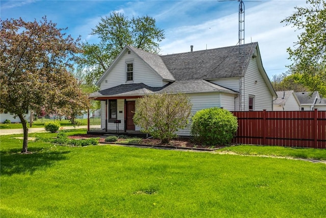 bungalow featuring a porch, a front yard, a shingled roof, and fence