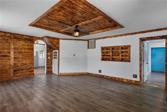 unfurnished living room featuring dark wood-style flooring, ceiling fan, visible vents, baseboards, and arched walkways