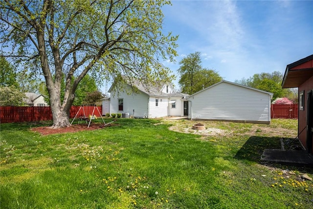 view of yard with central AC and fence
