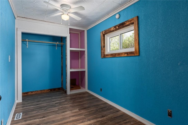 unfurnished bedroom featuring wood finished floors, visible vents, baseboards, and a closet