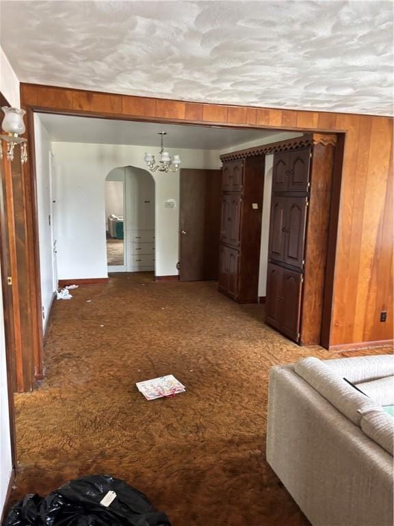106 W Wernsing Ave, Effingham, IL 62401 - living room with arched walkways, a chandelier, wooden walls, and carpet