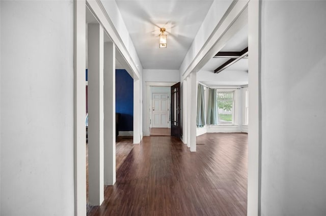 hallway featuring dark wood finished floors and baseboards